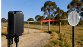 Long-range wireless beam-break sensor monitoring a rural gate with a passive reflector